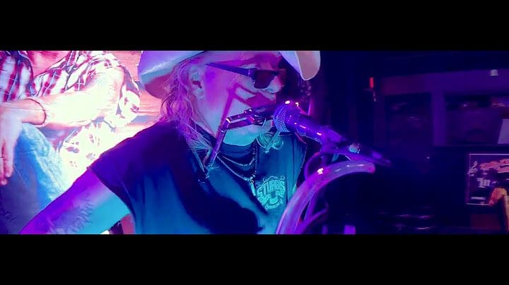 Musician passionately playing saxophone on stage with vibrant lighting.